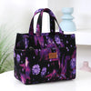 A purple and black cloth tote bag with a floral pattern is displayed on a white surface.