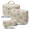 A set of three pink floral quilted cotton makeup organizers in sizes Large, Medium, and Small.