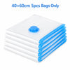 A stack of five clear blue vacuum storage bags for clothes.