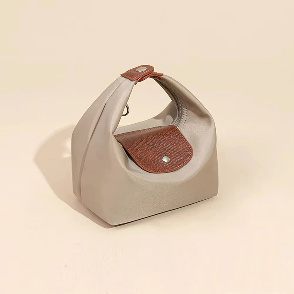 A light beige waterproof nylon crossbody bag with dual brown straps shown from above.