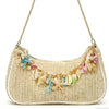 A beige woven straw shoulder bag adorned with colorful starfish and seashell charms.