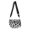 Black nylon crossbody bag with a white cow print pattern and black adjustable strap