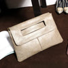 A beige sequined crossbody clutch bag resting on a dark brown surface.