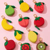 A collection of fruit-shaped PU leather coin purse keychains in yellow, green, and red colors.