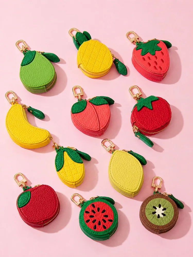 A collection of fruit-shaped PU leather coin purse keychains in yellow, green, and red colors.