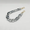 A silver and white multicolor acrylic chain bracelet with a twisted link design.