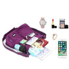 Lila Nylon-Crossbodytasche mit Accessoires wie Uhr, Lippenstift und Smartphone auf weißem Hintergrund