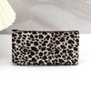 A brown and beige leopard print zippered cosmetic bag lying flat on a white surface.