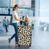 A person pulls a leopard print protective luggage cover on a rolling suitcase in an airport-like setting.