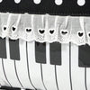 A black and white musical note tote bag featuring a piano lace trim and bow detail.