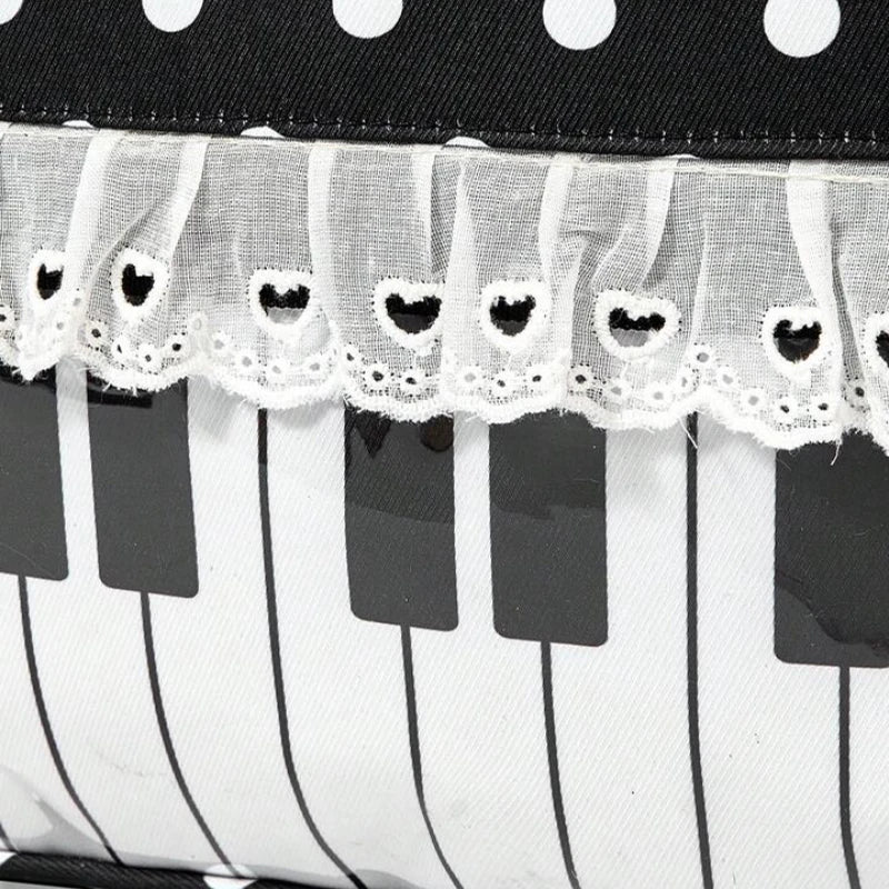 A black and white musical note tote bag featuring a piano lace trim and bow detail.