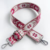 A pink and white floral jacquard strap for a crossbody bag, shown folded on a white background.