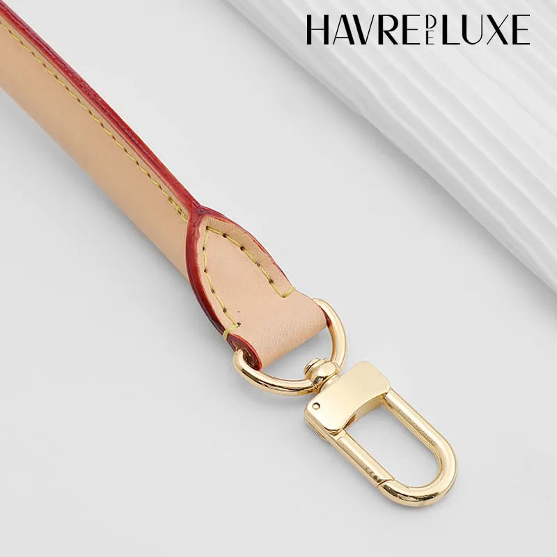 A tan cowhide leather replacement shoulder strap with a gold-toned buckle is shown against a white background.