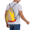 A person wearing a white t-shirt with a yellow and orange kraft paper drawstring bag slung over their shoulder.