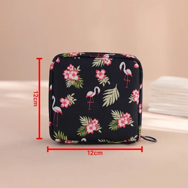 Black pouch with pink floral and flamingo patterns for storing sanitary pads or tampons