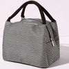 A black and white striped insulated lunch tote bag with a dark brown adjustable shoulder strap.