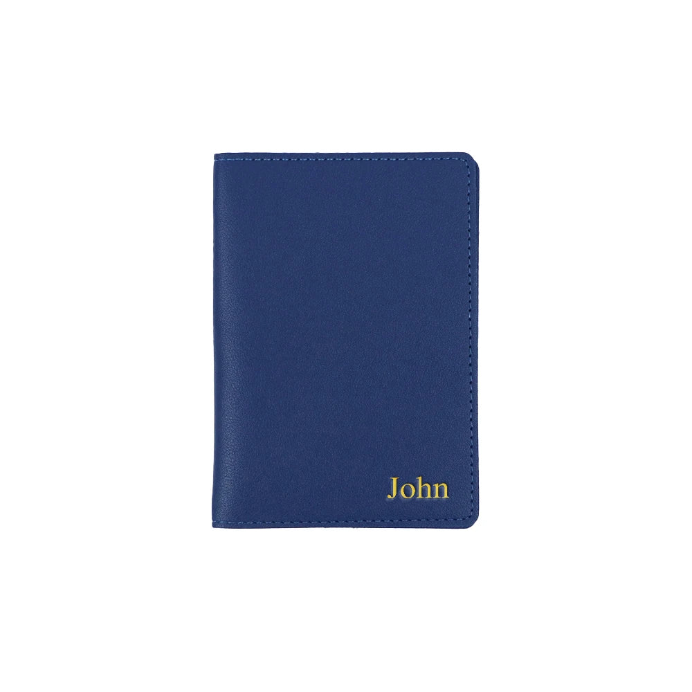 A dark blue PU leather passport holder with the name John embossed on the front.