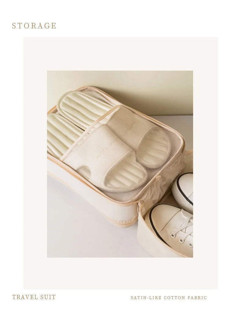 A beige fabric shoe organizer bag filled with white shoes, shown in a light neutral setting.