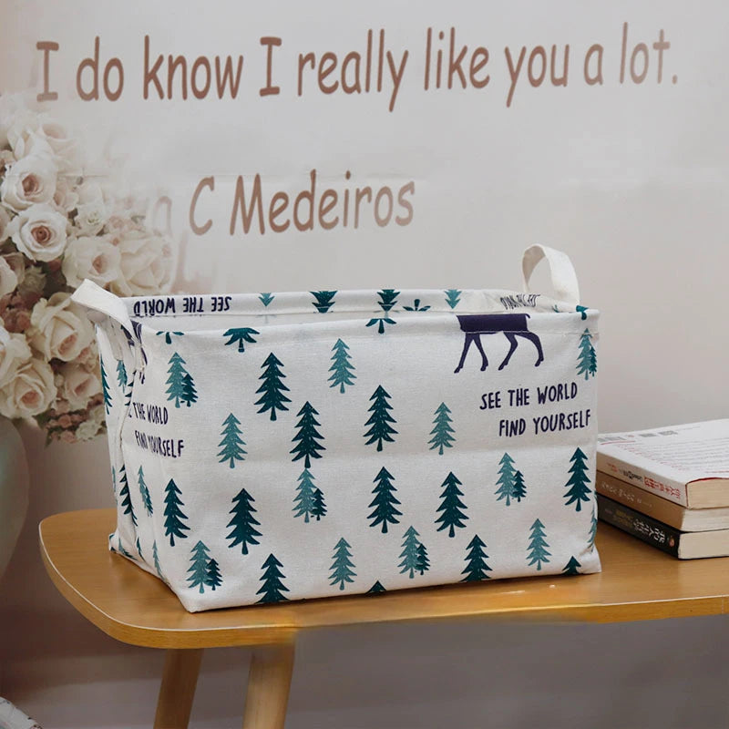 A white fabric storage basket with a green and purple pine tree pattern sits on a wooden shelf.