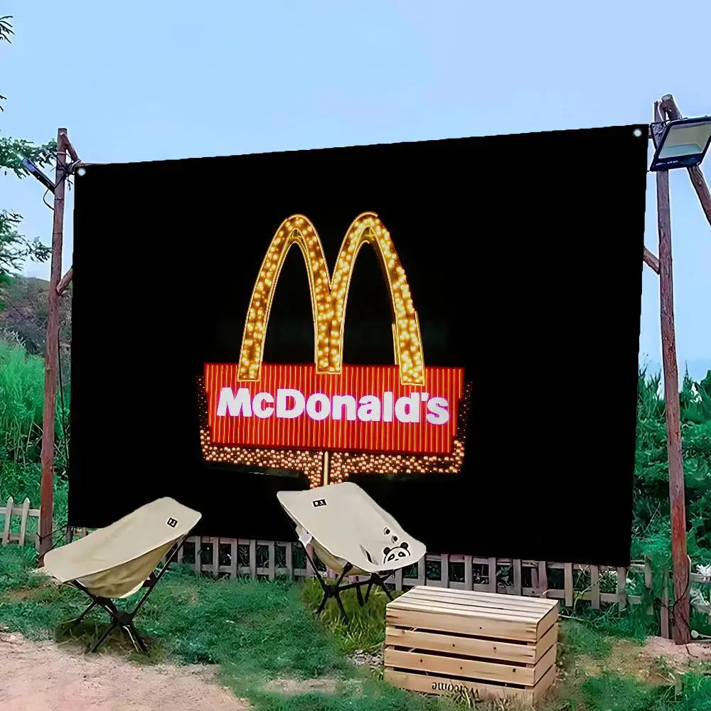 A large black banner featuring the McDonald's golden arches logo with bright lights, set outdoors.