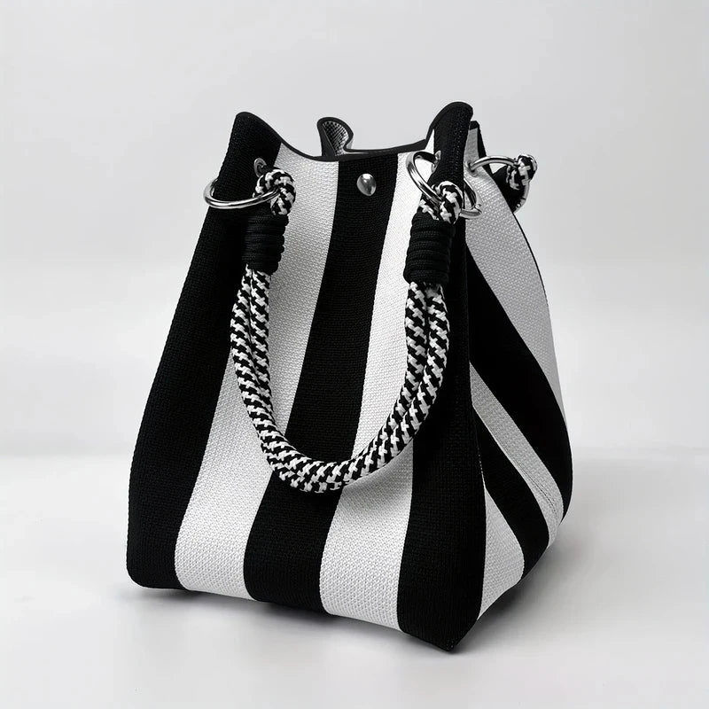 A black and white striped retro knitted bucket handbag with silver hardware.