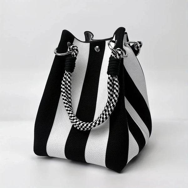 A black and white striped retro knitted bucket handbag with silver hardware.