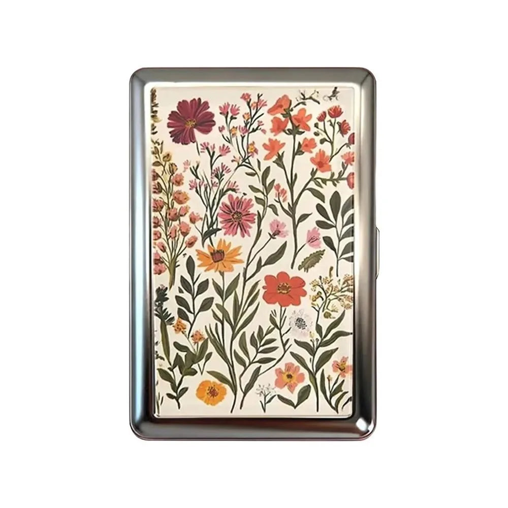 A vintage metal card holder featuring a floral pattern of pink, orange, and green botanicals.