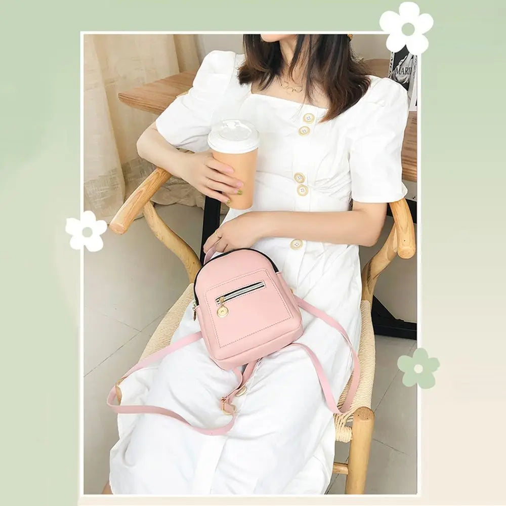 A woman is sitting and holding a pink waterproof PU mini backpack while wearing a white dress.