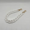 A white acrylic chain bracelet with gold-toned clasps.