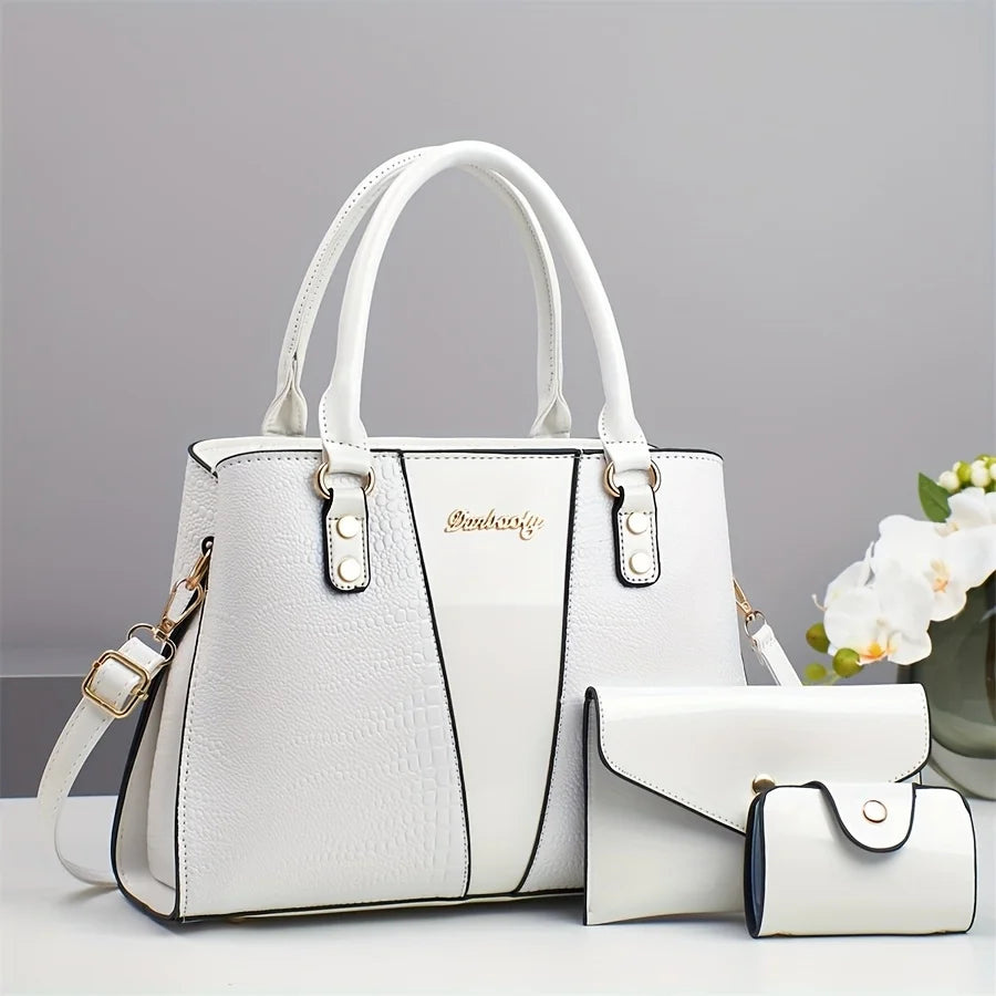 Un set de bolso de piel de cocodrilo de lujo blanco, con una tote grande y un clutch pequeño.