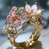 Gold rings featuring delicate pink and white flower and butterfly designs