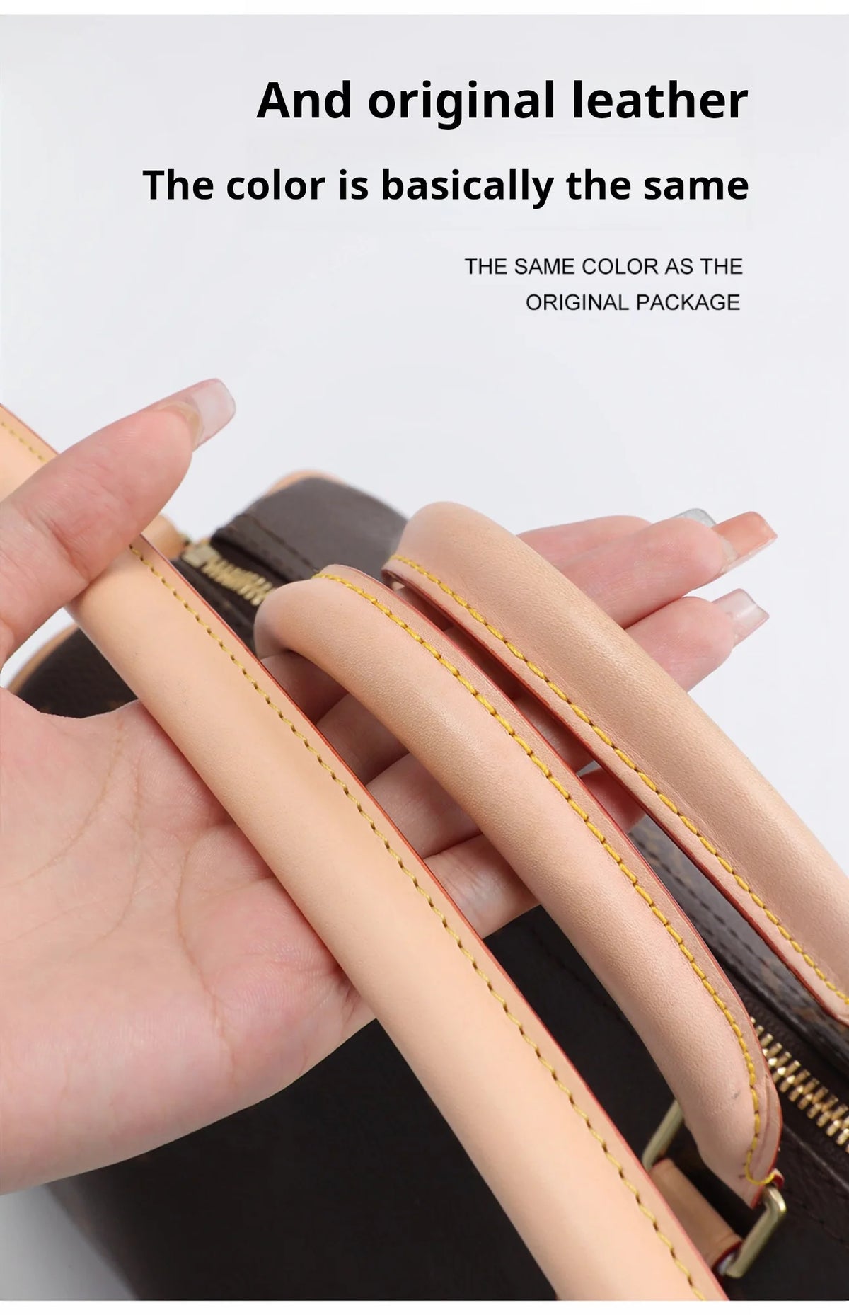 A hand is holding a tan leather strap from a black bag, showing the color matches the original package.