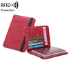 A red passport holder wallet with a black trim, featuring a charm and a passport cover.