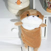 A fluffy brown otter plush toy standing on a white surface.