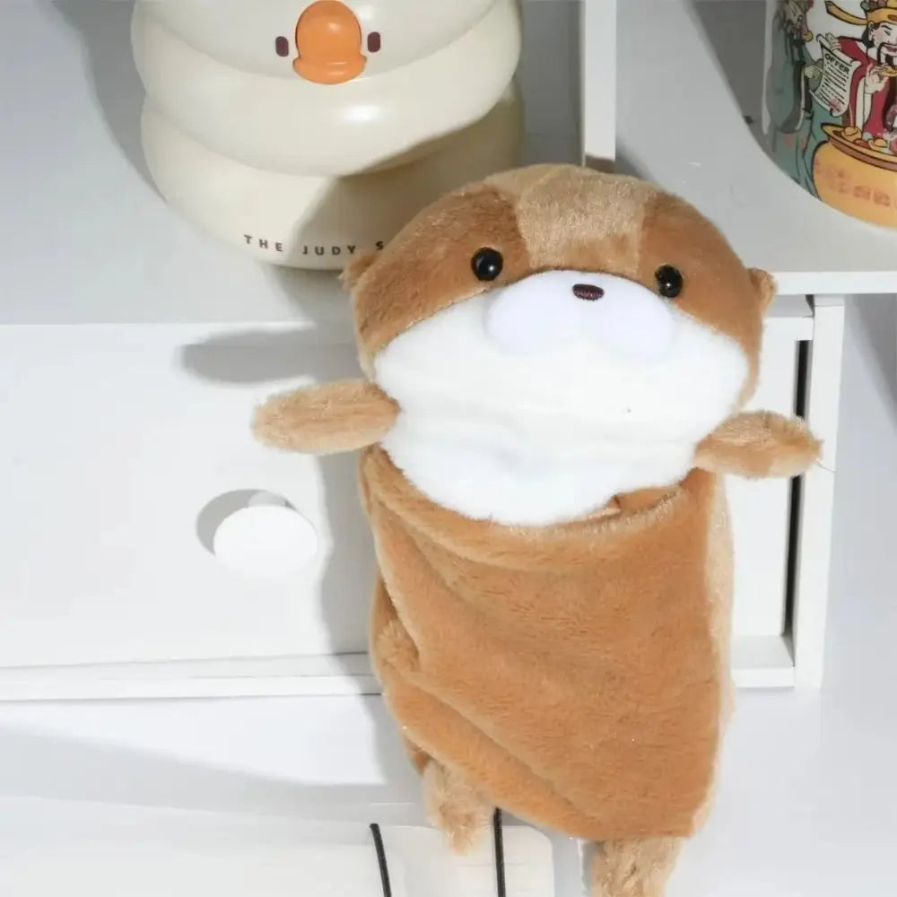 A fluffy brown otter plush toy standing on a white surface.