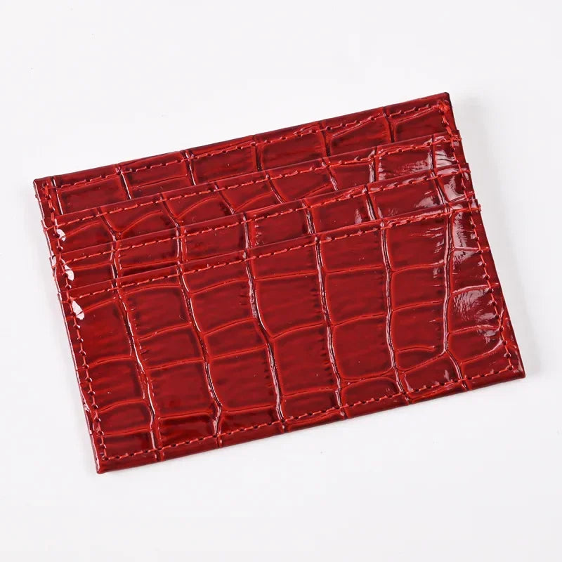 A rectangular red crocodile embossed PU leather card holder wallet.