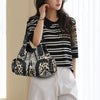 A woman models a black and white striped top and light pants while holding a leopard print PU leather tote bag.