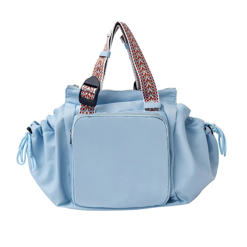 Light blue nylon shoulder bag with patterned strap and flap