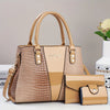 Bolso y cartera de cuero de cocodrilo beige exhibidos sobre una superficie blanca.