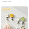 A set of translucent suction cup hooks used for bathroom storage, featuring pink and beige fabric items.