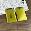 Two gold RFID metal card sleeves placed on a wooden surface next to a white laptop keyboard.