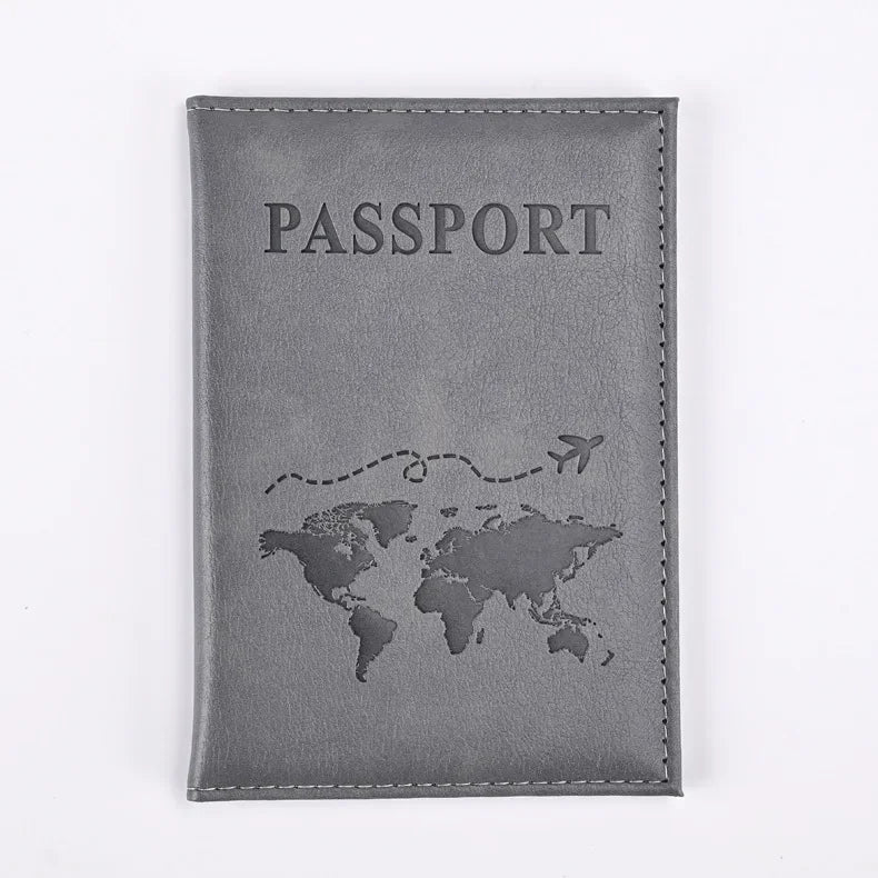 A dark gray leather passport holder with the word PASSPORT embossed and a world map design.