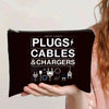 A hand holds a black zippered pouch labeled PLUGS CABLES & CHARGERS.