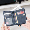 A hand holds a dark blue PU leather double fold wallet with various cards and cash inside.