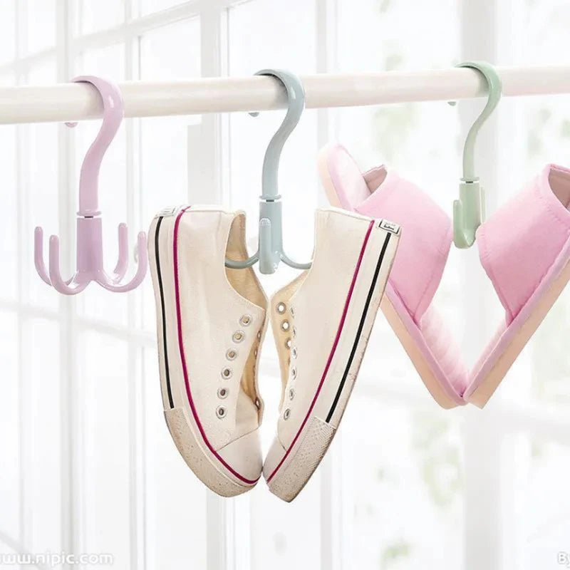 A pair of pink and beige shoes are hanging from a multi-functional hook on a white wooden bar.
