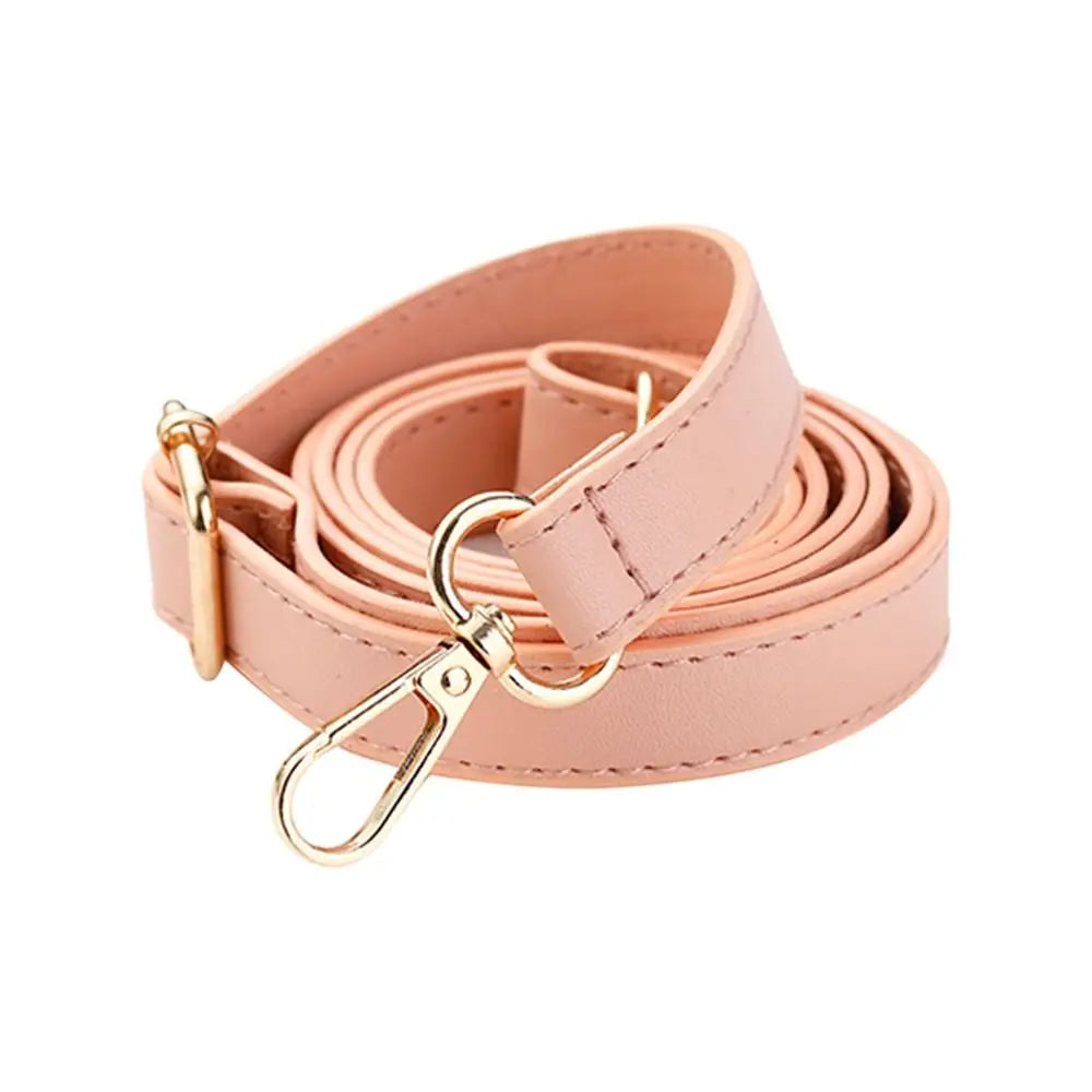 Une lanière de sac à main en cuir rose pâle ajustable avec une boucle dorée.