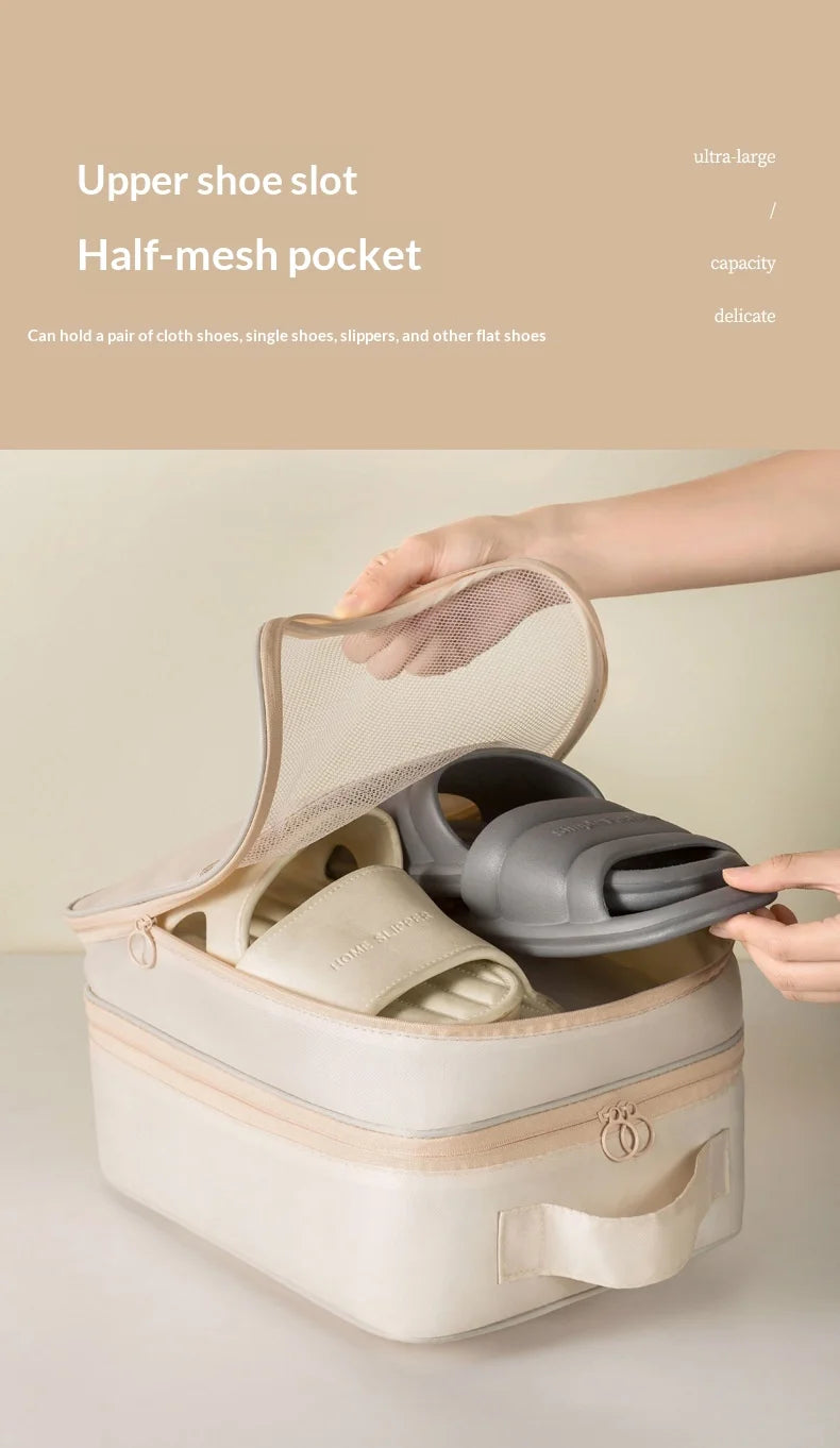 A hand is opening a beige portable luggage shoe organizer bag to show the upper shoe slot and half-mesh pocket.