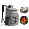 Gray insulated lunch backpack with a waterproof shell and an accessory tray containing fruit.
