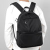 A black men's lightweight laptop backpack worn by a person in a white long-sleeved shirt.