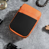 An orange and black fabric pouch designed to organize multi-tools and outdoor gear, shown on a gray surface.